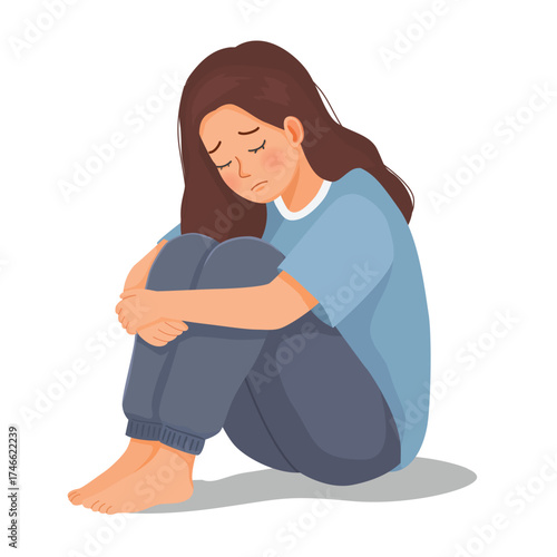 Woman feeling sad, upset, and crying sitting on the floor hugging her legs