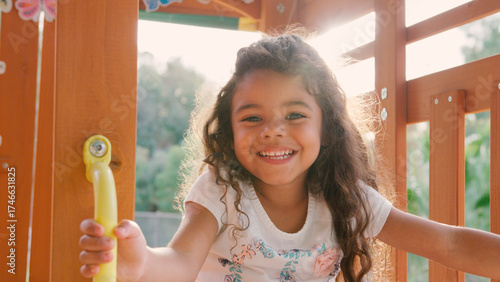 Tableau sur toile Portrait Of Smiling Young Girl Climbing On Equipment In Playground