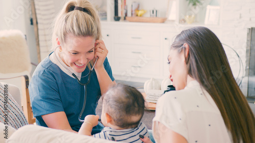 Female Health Visitor Talking With Mother Holding Baby Son At Home