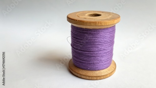 Purple thread on wooden spool for crafting and sewing projects