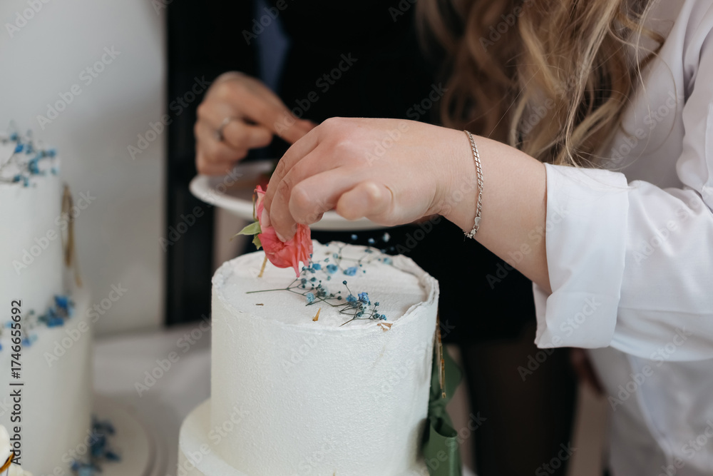 Obraz premium Decorating a beautiful cake with flowers and herbs during a special event in a cozy venue