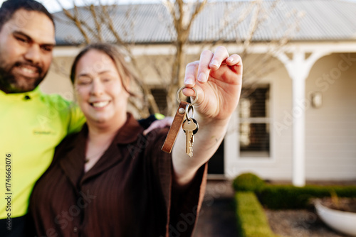 Mixed ethnicity couple showing keys of their new home