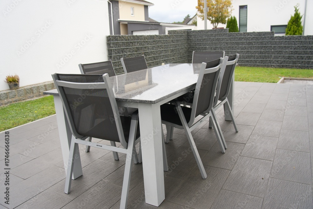 Fototapeta premium Modern patio furniture set on paving in backyard