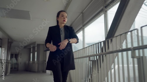 Wallpaper Mural Asian businesswoman walking while holding tablet and using smartphone. Concept of multitasking, digital lifestyle, and modern work efficiency. Torontodigital.ca