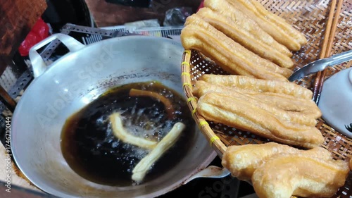 The process of frying fried bread or cakwe. Also known as Youtiao or Cakoi, this food is very popular among Chinese Indonesians, Malaysians, and Singaporeans as a breakfast dish.