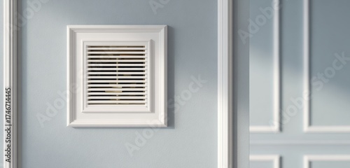 Close up of a white air vent installed on a smooth light gray interior wall