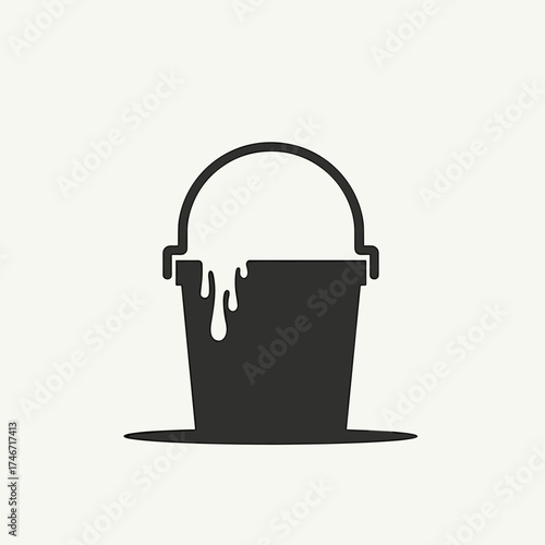 Paint bucket with dripping paint, construction site equipment used to carry paint. Black paint bucket, full of paint, shown with spilled paint as a sign of artistic expression.