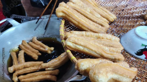 The process of frying fried bread or cakwe. Also known as Youtiao or Cakoi, this food is very popular among Chinese Indonesians, Malaysians, and Singaporeans as a breakfast dish.
