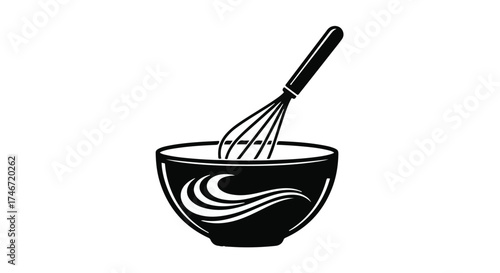 Whisk mixing ingredients in a black bowl, perfect for culinary creations.