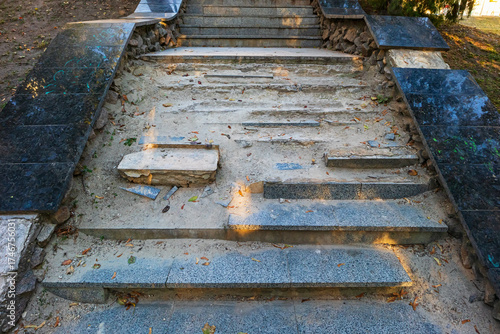 The steps of an old stone staircase are crumbling and the concrete is crumbling. This is an infrastructure problem in a public park or city street
