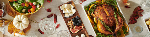 Tableau sur toile Roast turkey garnished with herbs surrounded by autumn leaves, salad with cherry