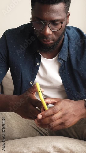 Focused african american man texting on a smartphone