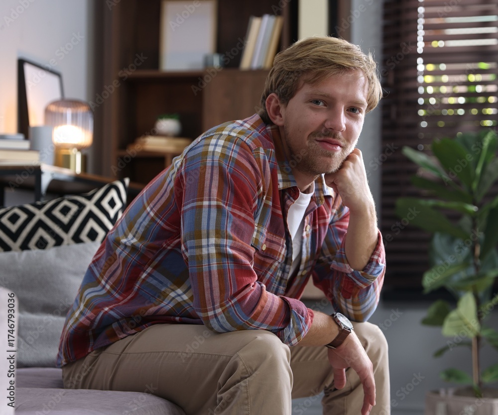 Fototapeta premium Portrait of man sitting on sofa at home