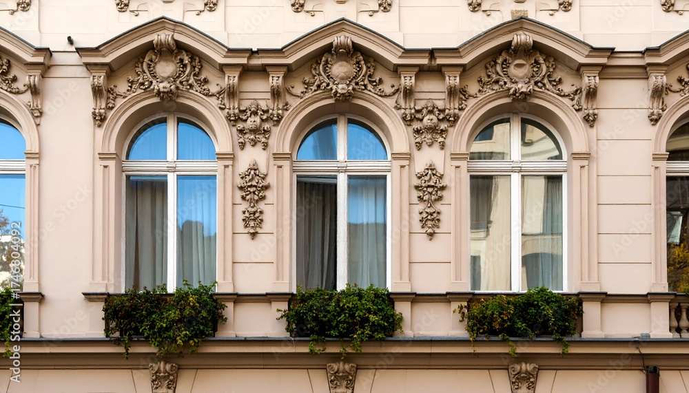 Obraz premium Ornate architectural details adorn the facade of a building, featuring arched windows and decorative elements.