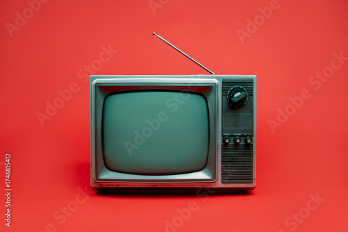 Front view, retro red old television with blank screen, vintage analog old fashioned TV isolated on red background.