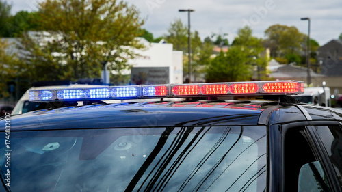 Emergency response vehicle with flashing lights parked during daytime in a city setting