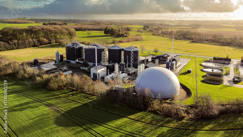 Drone view of a large biogas production facility surrounded by green farmland in Denmark, highlighting renewable energy infrastructure and sustainable rural technology.