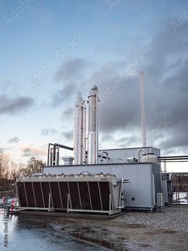 Detailed view of a modern biogas installation in rural Denmark, showing tanks, pipes, and clean energy infrastructure producing renewable gas from organic waste from farms