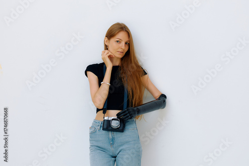 Woman with bionic prosthesis poses confidently while holding a camera in a bright indoor setting