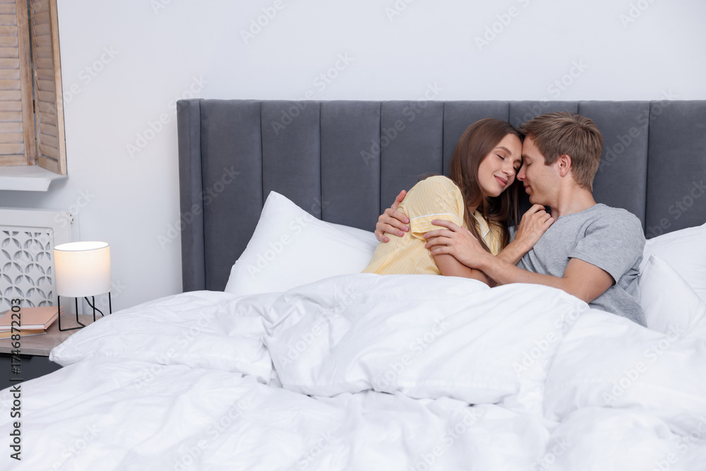Fototapeta premium Happy couple enjoying each other in bed at home