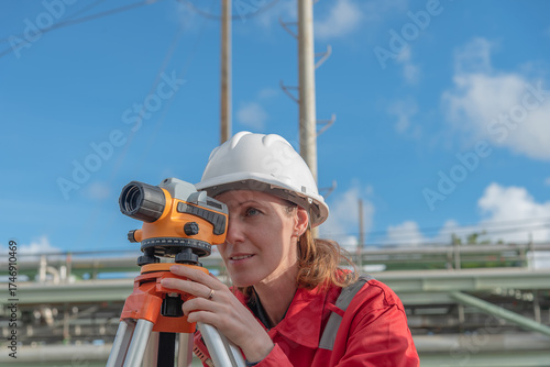 Woman engineer using theodolite outdoors