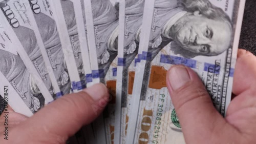 Counting stacks of cash in a well-lit room while enjoying the satisfying rhythm of money rustling