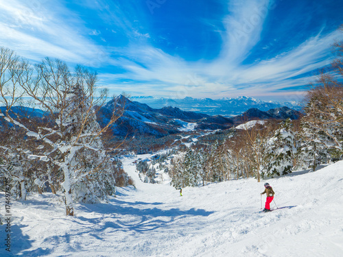 Skier on an ungroomed ski slope under a dramatic sky (Yokoteyama, Shiga Kogen, Nagano, Japan)