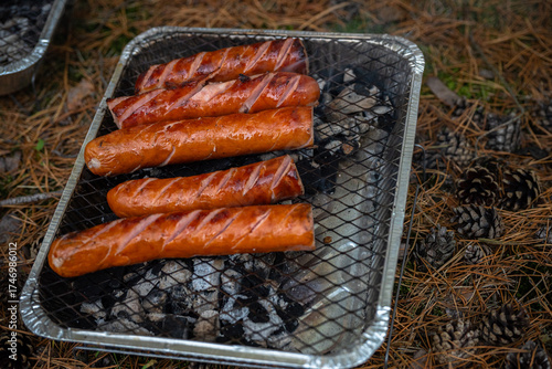 Cooking sausages outdoors on a disposable grill