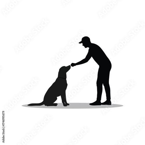 Silhouette of a person wearing a baseball cap giving a treat to a sitting black labrador dog on a white background