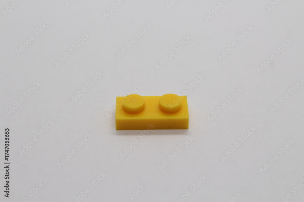 Obraz premium Yellow Lego brick piece isolated on a white background
