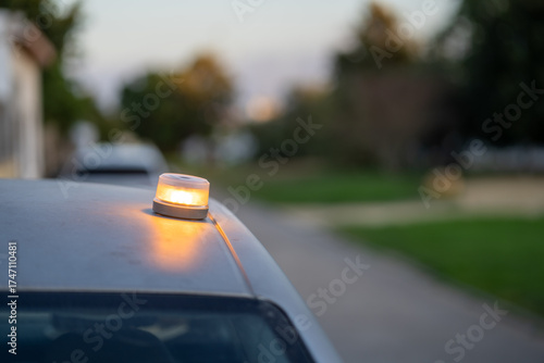 Red emergency light glowing on the roof of a vehicle at night, realistic close-up symbolizing security, urgency, rescue response, and public safety in low-light urban environment