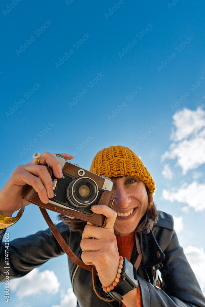 Obraz premium young girl with a camera. photographer with camera. Stylish girl with a film camera. takes a shot.