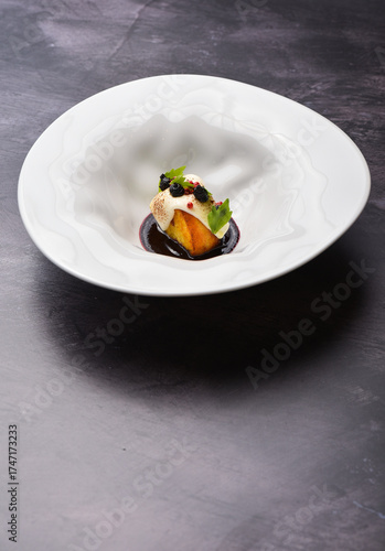 Exquisite restaurant dessert. Caramel milfuelle with spicy pear, berry sauce and almond flakes on white plate finely decorated with candy spiral. Exclusive meals and haute cuisine concept