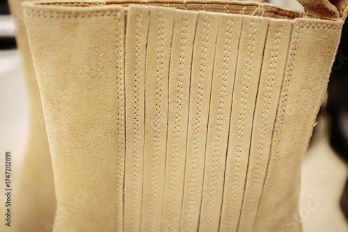 Stylish beige suede western boots with a pointed toe and angled block heel, perfect for adding a chic cowboy-inspired touch to casual or dressy outfits.