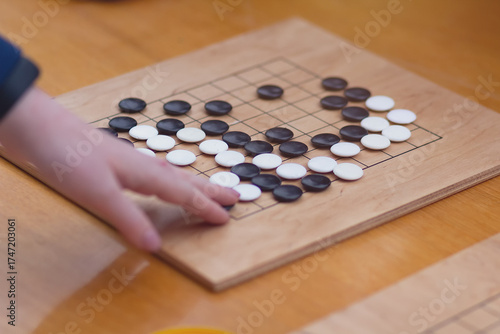 Chinese go game board, close up view of playing black and white stone pieces