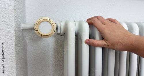 Hand Touching White Radiator for Heating Check — Home Maintenance and Energy Efficiency Concept Indoors