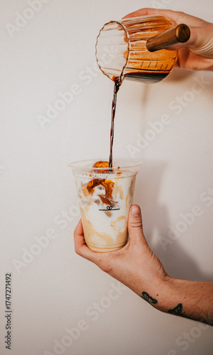 A person is pouring a drink into a cup