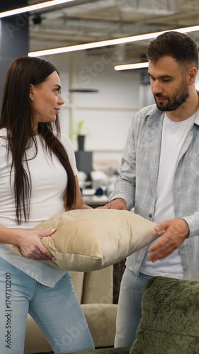 Young couple choosing decorative pillows in a furniture store
