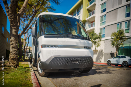 Electric delivery truck parked on a street sidewalk.