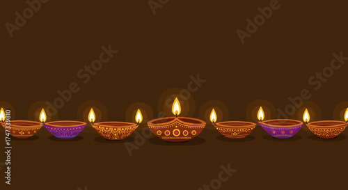 Lit diyas arranged in a row against a brown background creating a festive ambiance