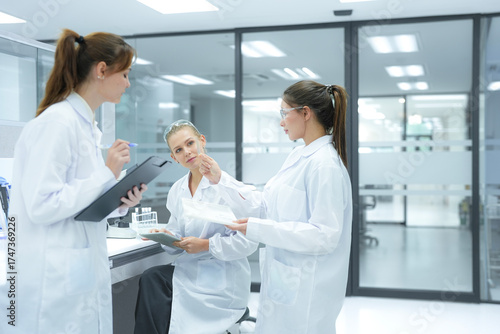 Researchers in a state of the art R and D institute discuss their findings. The facility's cleanroom design and open layout foster collaboration for complex pharmaceutical projects.