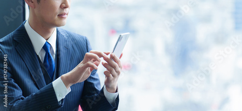 スマートフォンを使う40代の会社員の手元