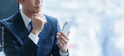 スマートフォンを使う40代の会社員の手元