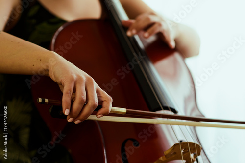 Cello player bow on strings close up