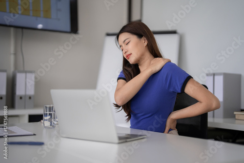 Asian adult business woman neck shoulder back pain working office desk poor posture fatigue stress long hours corporate environment