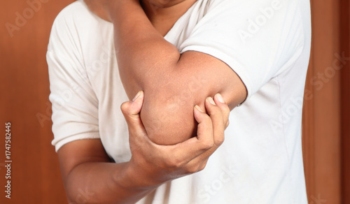 Wallpaper Mural Pain in the elbow. The man holds his hand. Close up. Torontodigital.ca