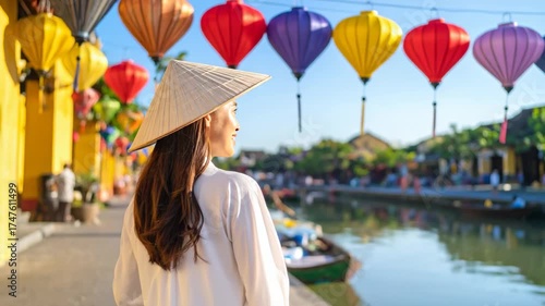 Woman with a conical hat looking at colorful lanterns and a canal