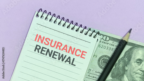 Photos Insurance renewal notice on notepad with hundred dollar bill and pencil on desk