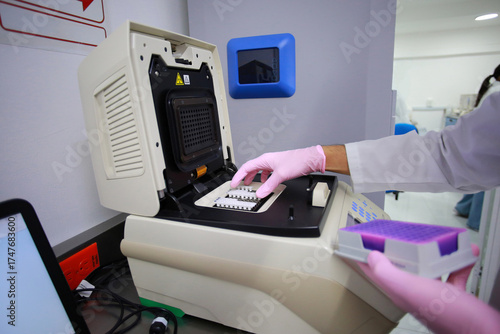 Expert biologist places patient samples in the laboratory«s PCR machine