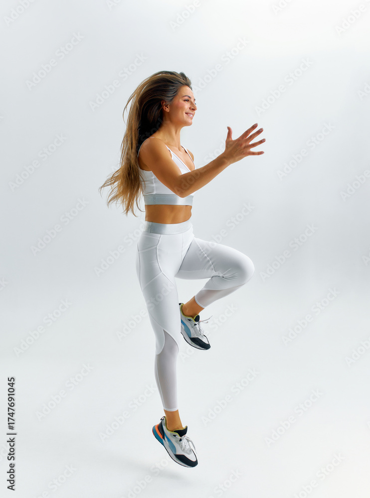 Fototapeta premium Woman showcases her athleticism by performing a dynamic workout routine